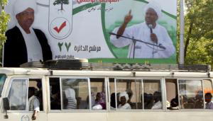 AP  Los pasajeros de un autobús pasan junto a uno de los carteles electorales del presidente Omar Hassan al Bashir, ayer en Jartum