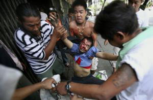 AP  Un hombre con un balazo en la cabeza era evacuado ayer en Bangkok por los manifestantes