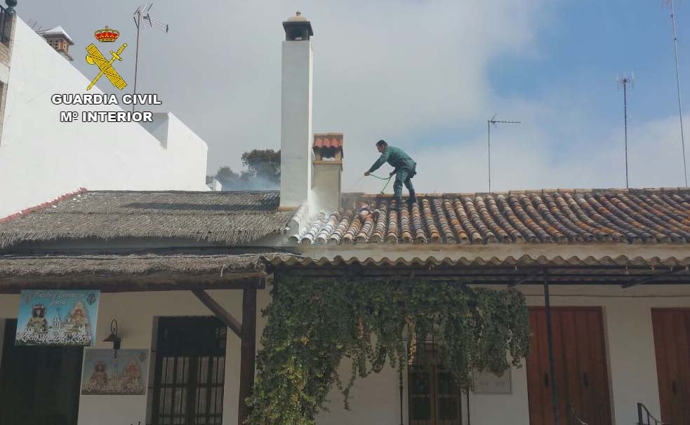 Un guardia civil en el tejado de la casa para frenar las llamas