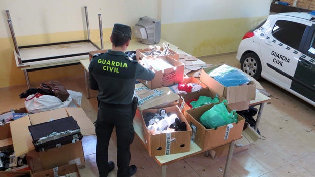 Agente inspecciona el material decomisado a los detenidos