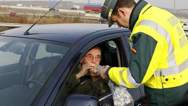 Un hombre mayor pasa un control de alcoholemia.