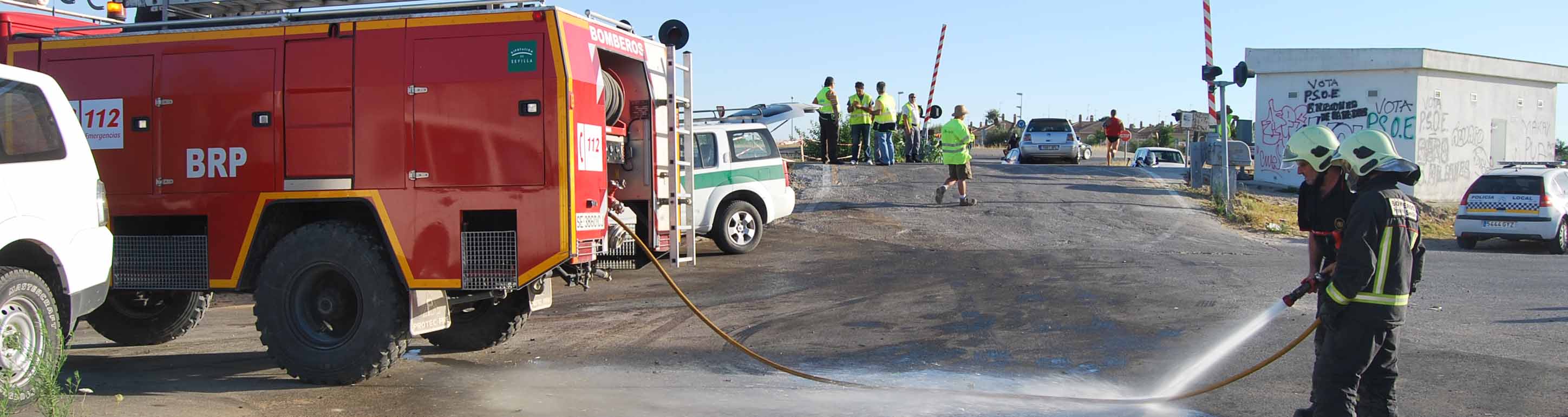 Los bomberos limpian la zona después de un accidente en un paso a nivel de Utrera