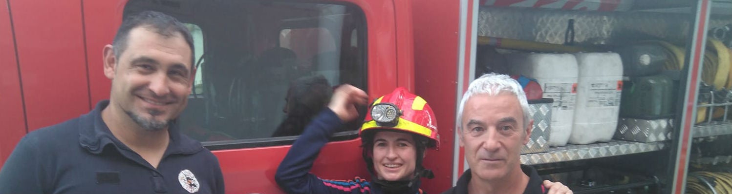 Dos bomberos flanquean a la joven que rescataron del cementerio de San Eufrasio.