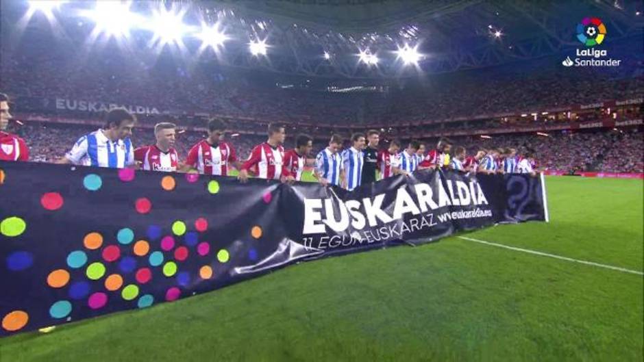 Los jugadores del Athletic de Bilbao y la Real Sociedad posan con una pancarta antes del inicio del partido