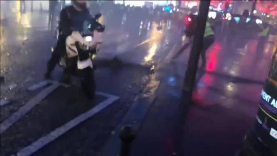 Un policía apunta con su arma a la multitud que les asa nueva protesta de los 'chalecos amarillos'
