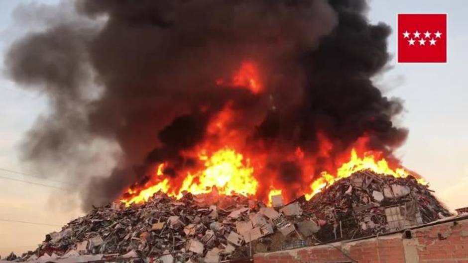 Bomberos trabajan en la extinción de una montaña de chatarra