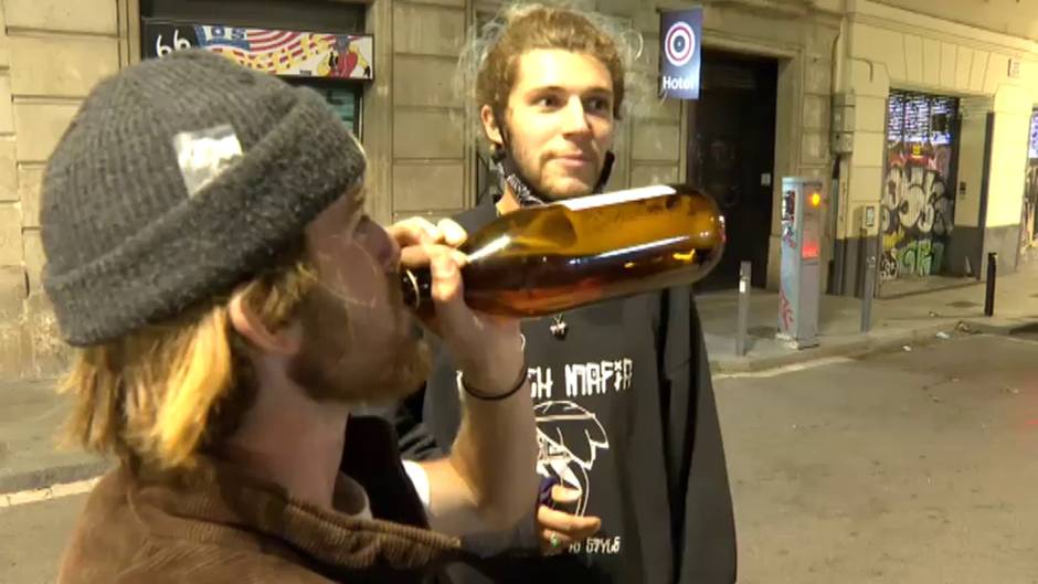 Turistas extranjeros intentan evitar que les graben bebiendo en la calle sin mascarilla ni distancia de seguridad en Barcelona