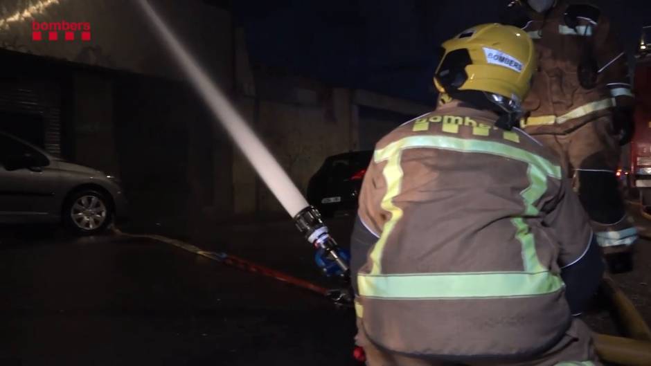 Bomberos trabajan para sofocar el fuego en una nave okupada en Badalona