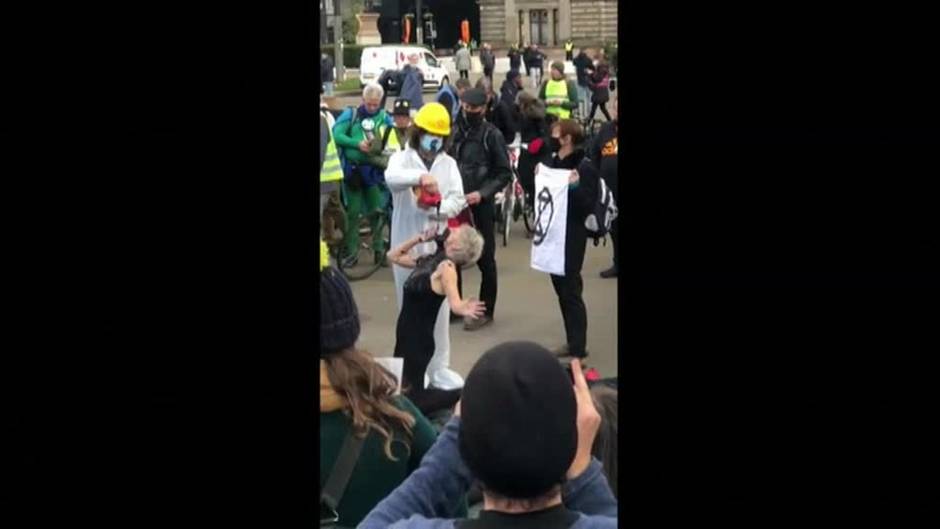 Una activista simula beber petróleo durante una protesta en la cumbre climática de la ONU