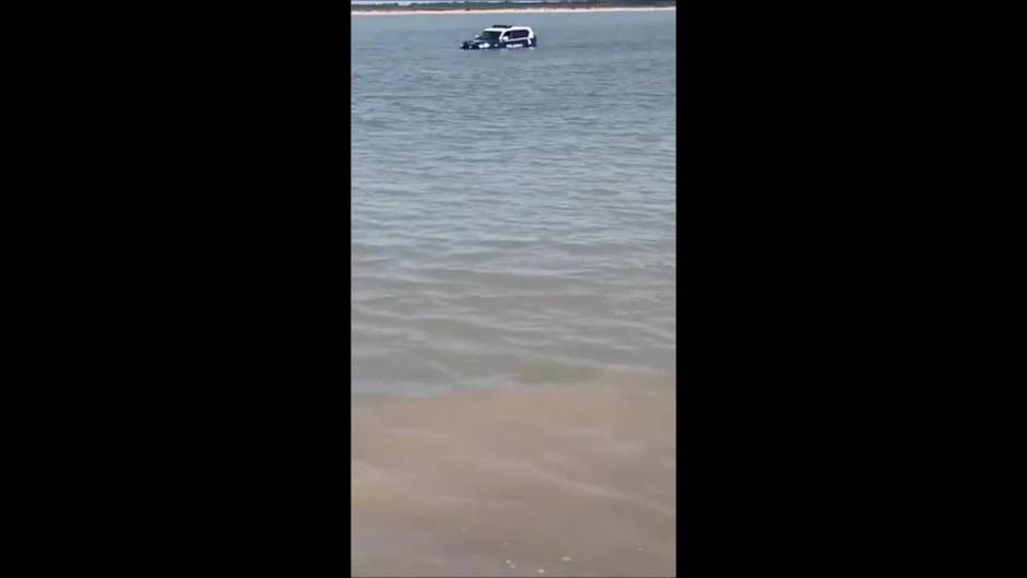 Vídeo: Un coche de la Policía Nacional encalla en la playa de Sanlúcar y acaba sumergido