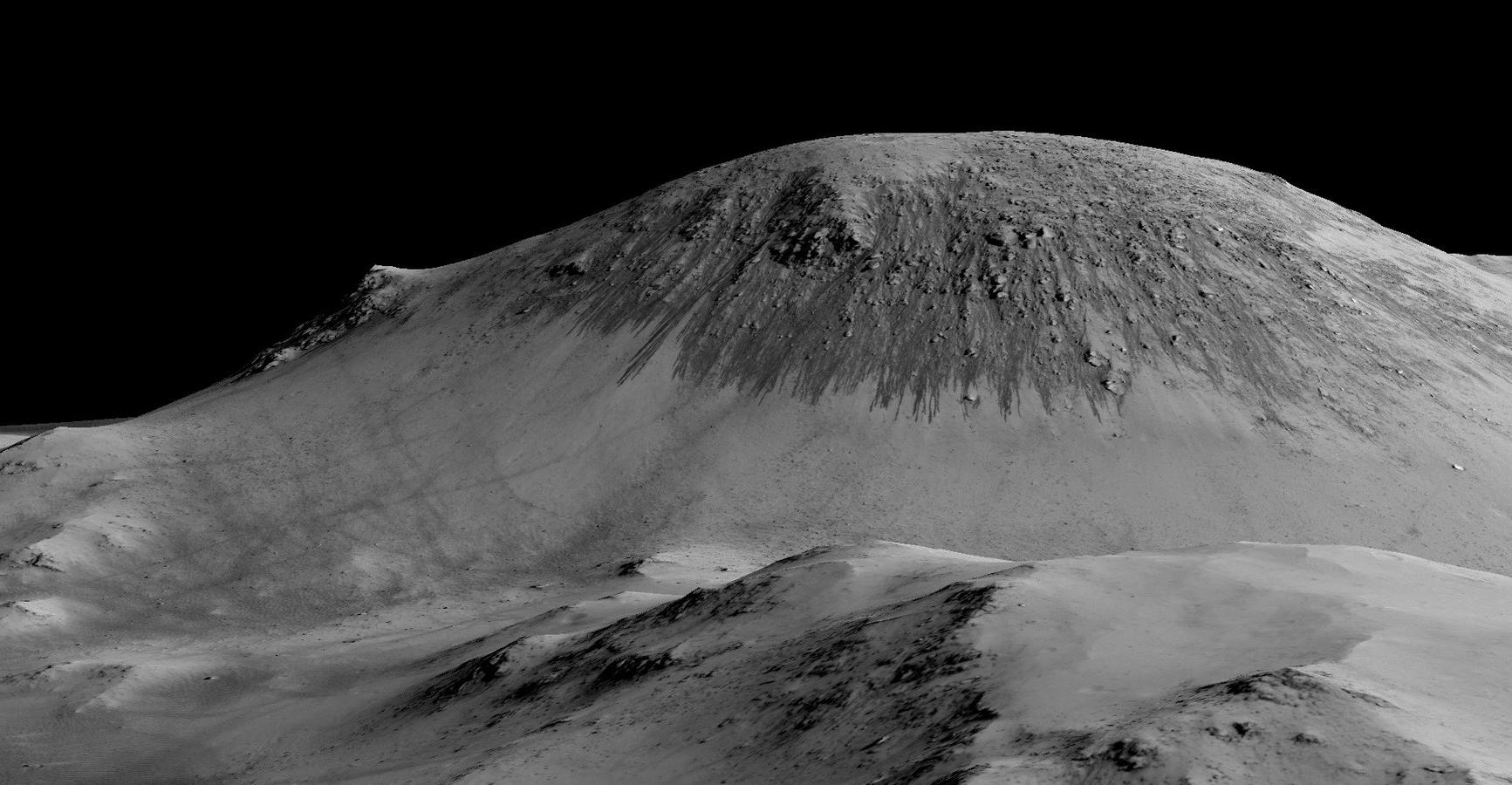 Foto facilitada por la NASA que muestra las oscuras y estrechas rayas, de 100 metros de largo, que discurren cuesta abajo en Marte, las cuales se deduce que se han formado por el fluido del agua. 