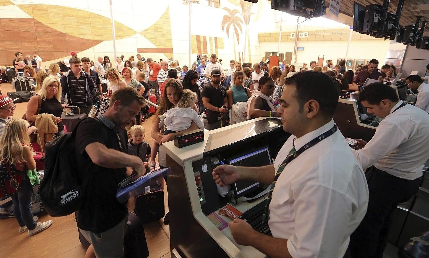 Un grupo de turistas espera frente a los mostradores de facturación del aeropuerto de Sharm el-Sheij. 