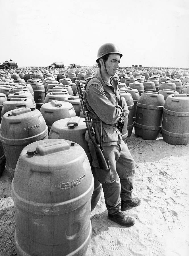 40 años de la Marcha Verde, en imágenes. Un soldado marroquí monta guardia ante los bidones que contenían el agua, para los «voluntarios» de la Marcha Verde