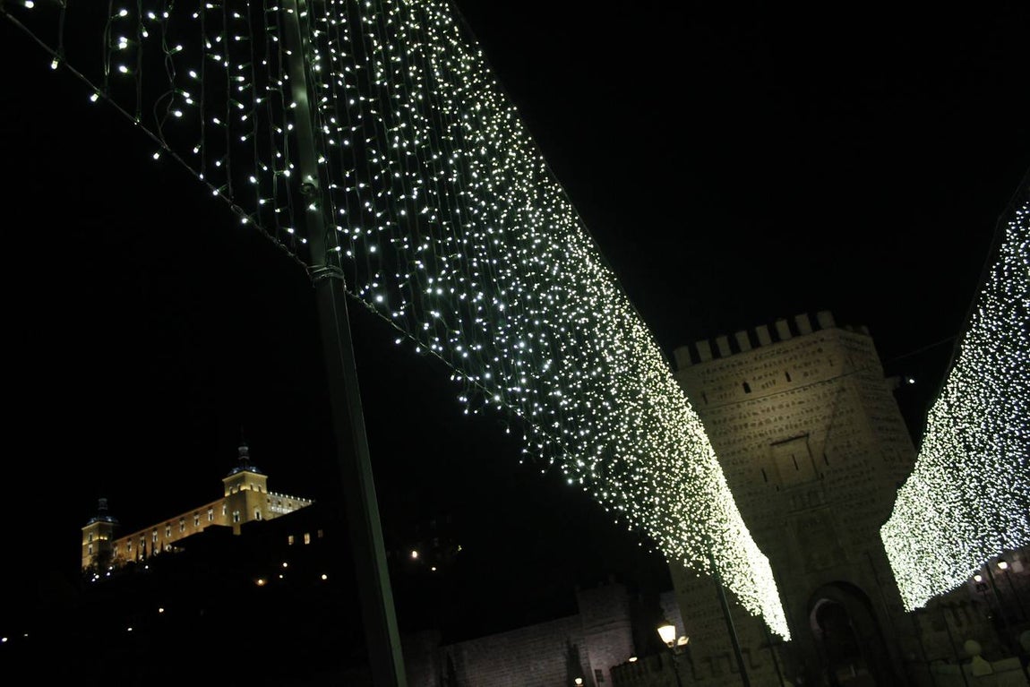 El Alcázar iluminado se asoma al puente. 