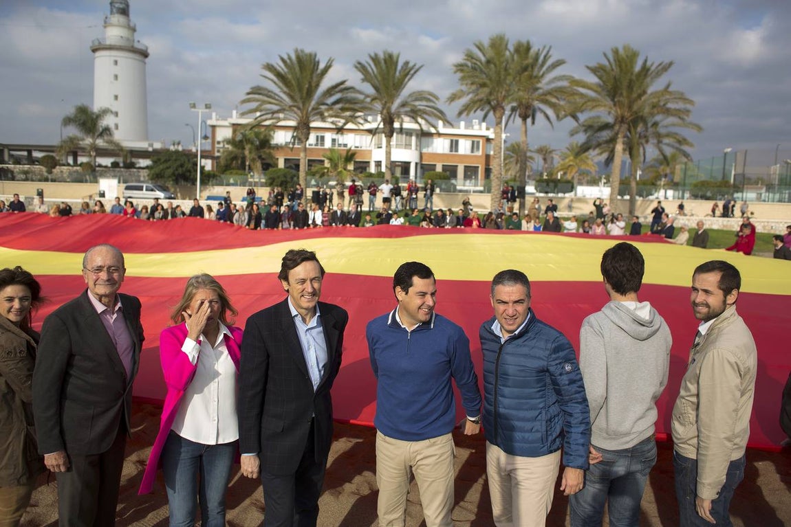 El portavoz del PP en el Congreso de los Diputados, Rafael Hernando (4i), el presidente del PP andaluz, Juanma Moreno (4d), el presidente del PP de Málaga, Elías Bendodo (3d) y el alcalde de Málaga, Francisco de la Torre (2i), participan en el acto de despliegue de la bandera de España más grande del país. 