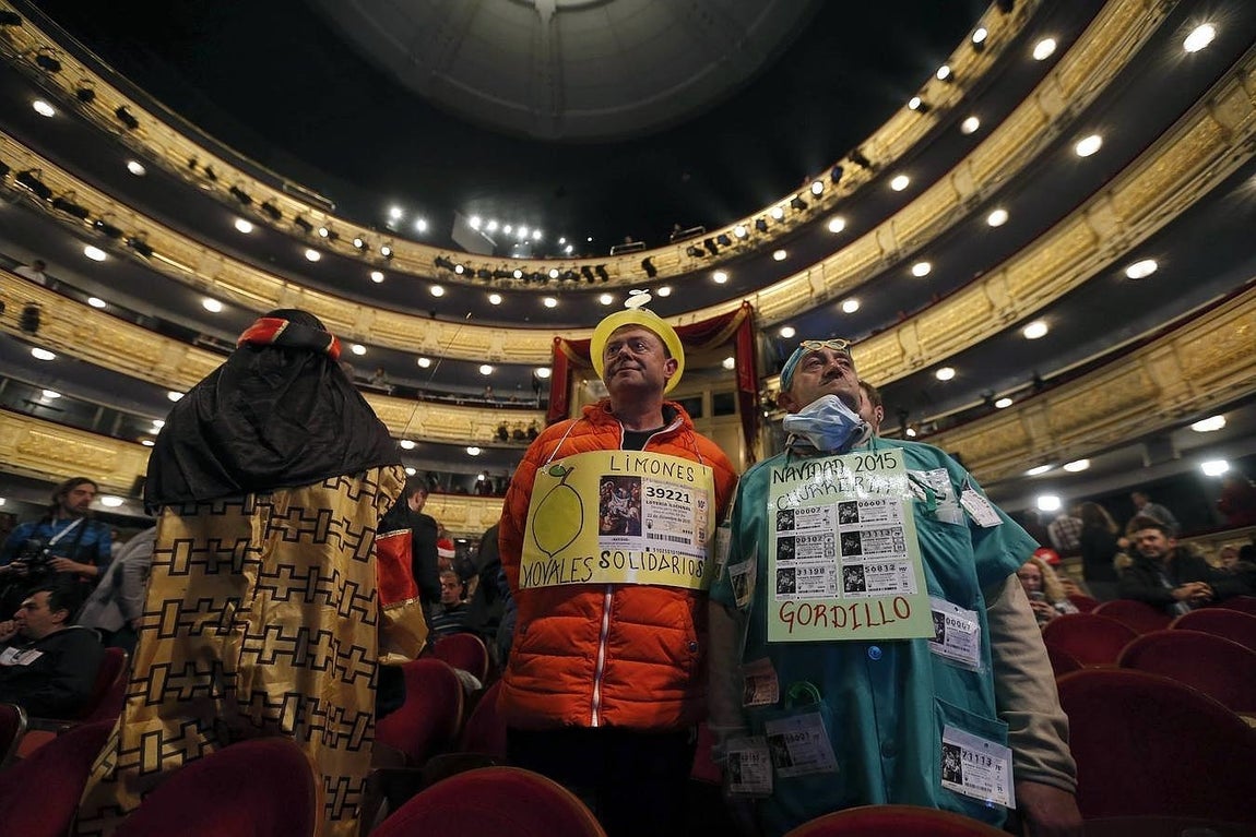 Algunas personas disfrazadas esperan en el interior del Teatro Real a que dé comienzo el Sorteo Extraordinario de Navidad, para vivir de cerca el instante en que los niños de San Ildefonso canten el Gordo. 