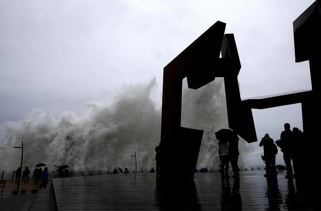 Una ola junto a la escultura «Construcción vacía», de Jorge Oteiza, en el Paseo Nuevo de San Sebastián, donde se ha decretado la alerta naranja por fenómenos costeros. 