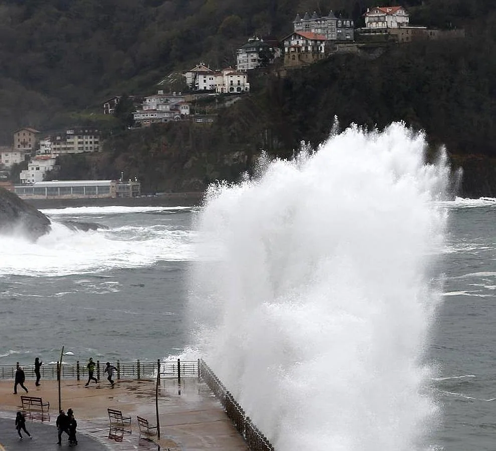  Varias personas huyen de una ola en el Paseo Nuevo de San Sebastián