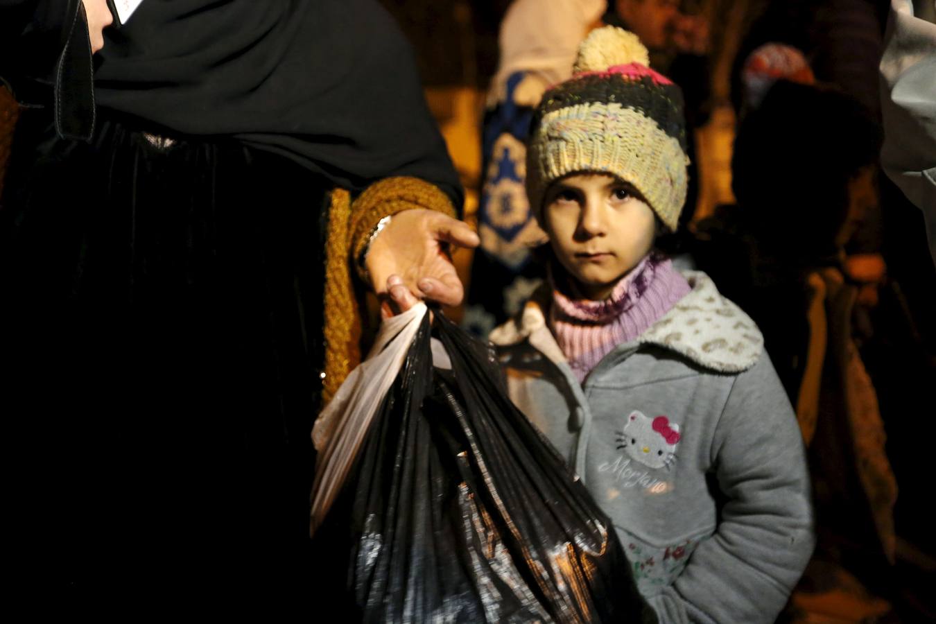 Una niña siria espera en Madaya junto a su familia, cuyos miembros aseguran haber recibido permiso del gobierno sirio para salir de la ciudad sitiada, después de que entrara un convoy con ayuda. 