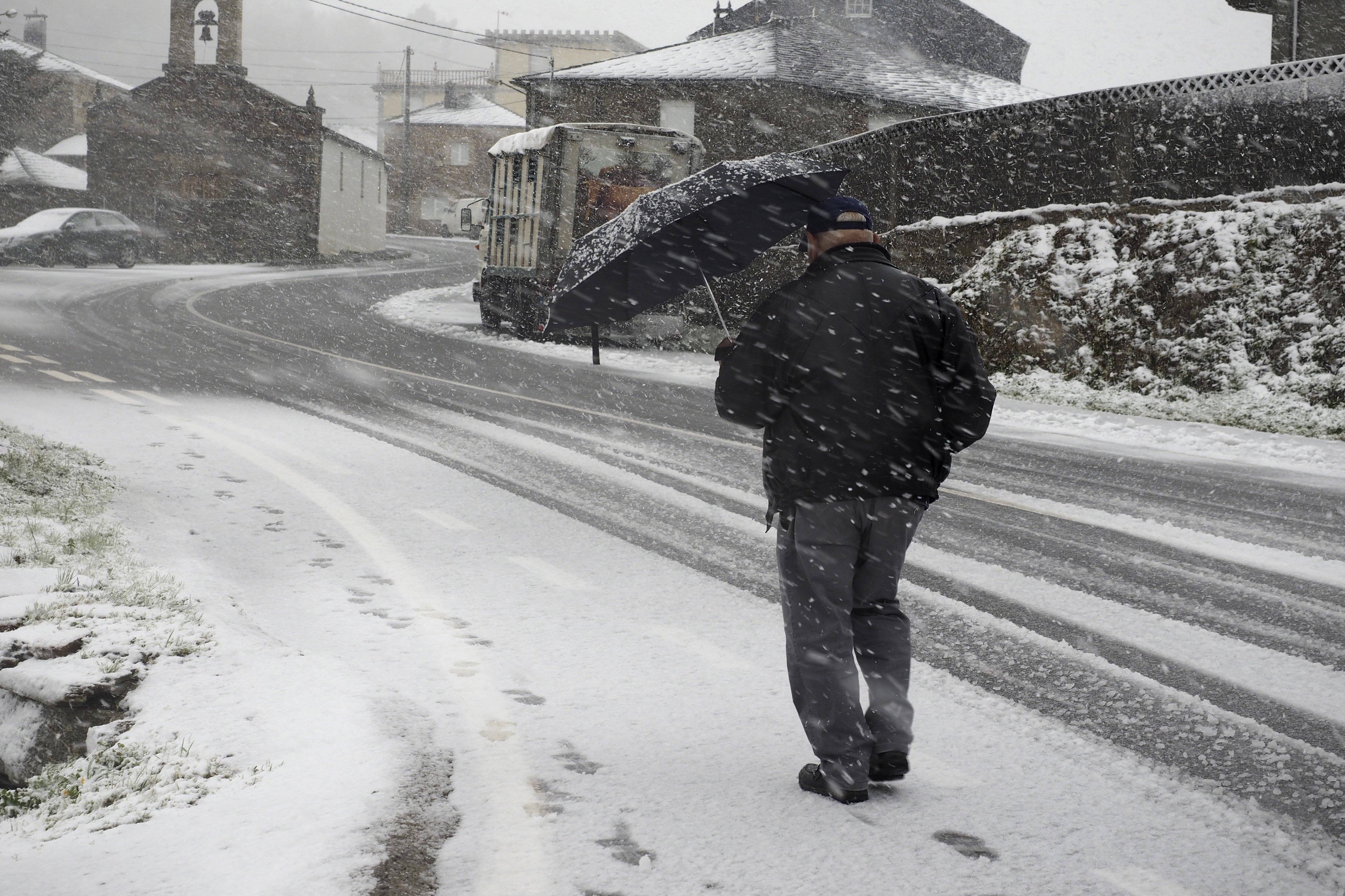 Un vencino de O Cádavo (Lugo) se protege de la nieve. 