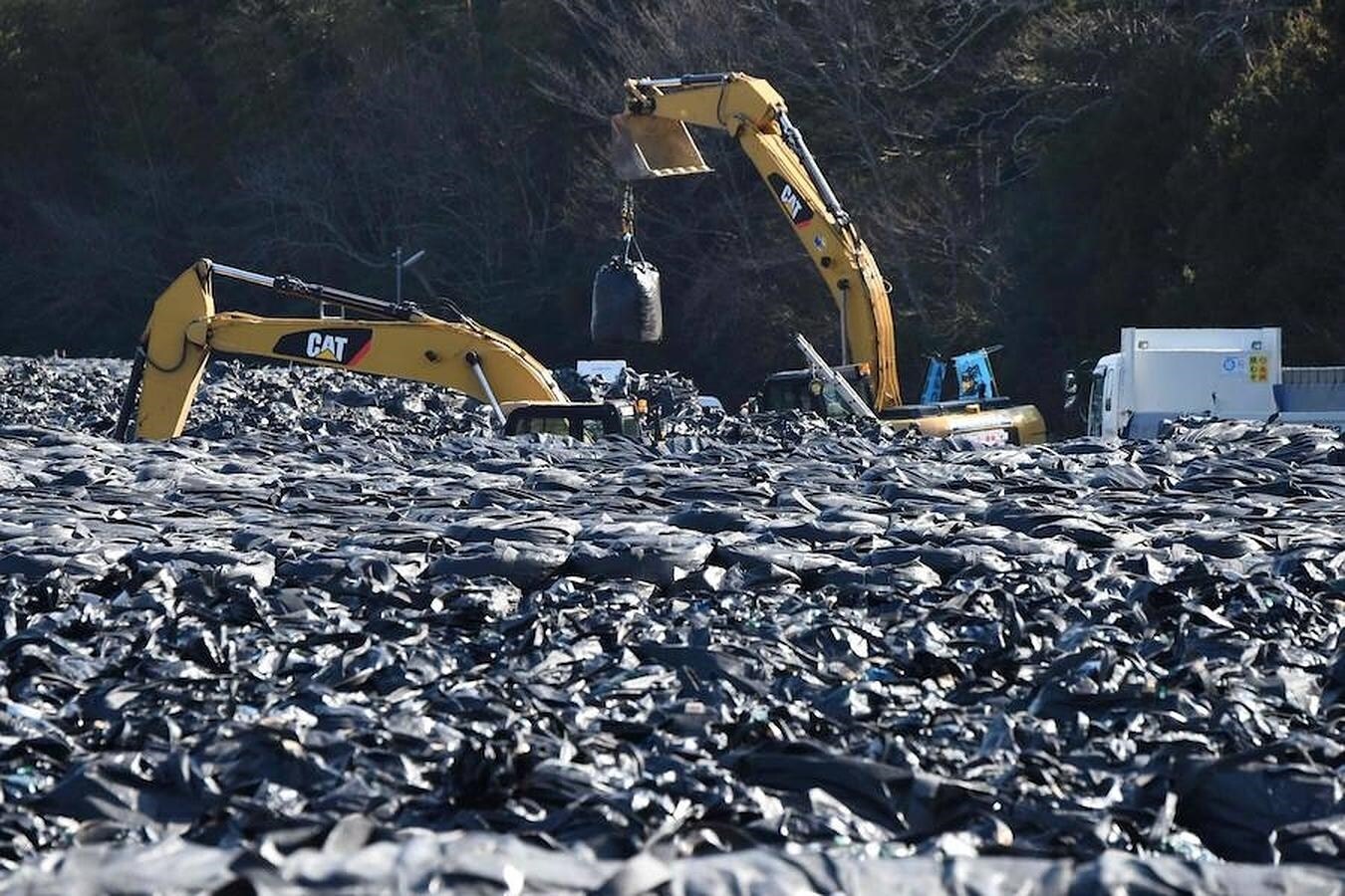 Excavadoras apilan residuos nucleares de forma provisional en Tomioka, en la prefectura de Fukushima.