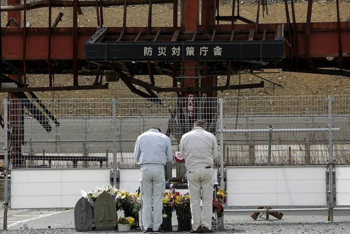 Un grupo de visitantes muestra sus respetos a las víctimas en un altar improvisado en el antiguo Centro de Prevención de Desastres de Minamisanriku, la perfectura de Miyagi (Japón) este jueves.. 