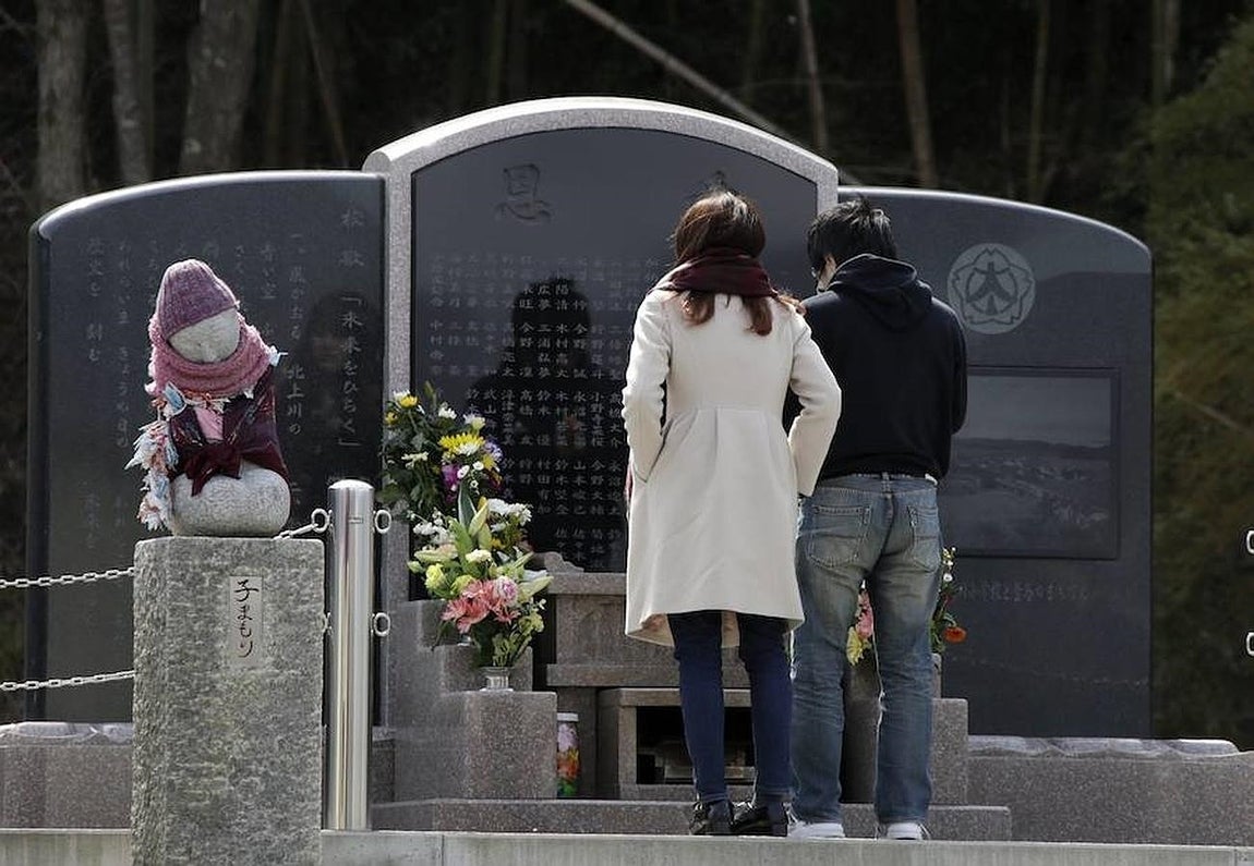 Un grupo de visitantes muestra sus respetos a las víctimas en un altar improvisado en la devastada escuela primaria de Ishinomaki, la perfectura de Miyagi (Japón) este jueves,. 