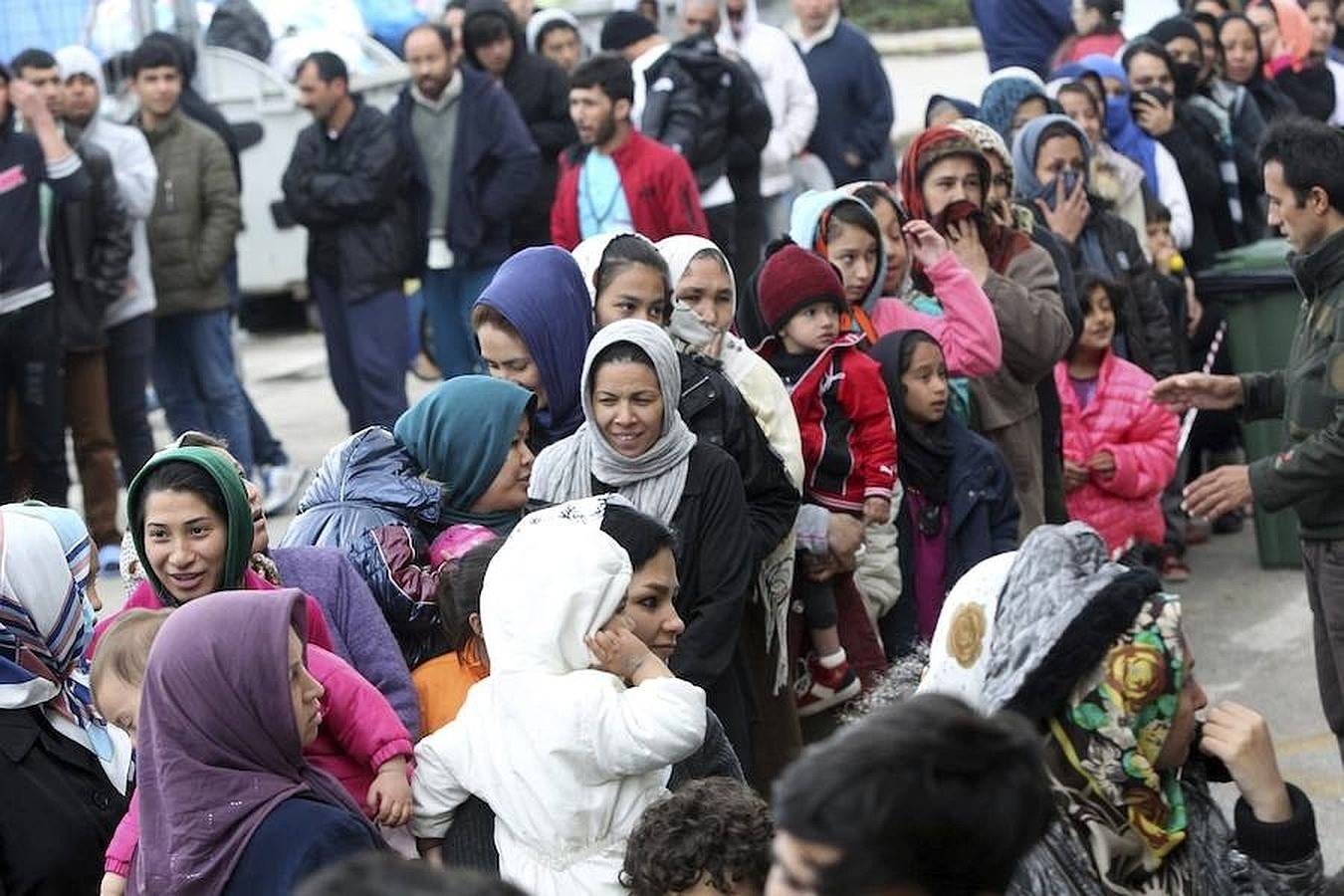 Refugiados esperan para recibir comida en el antiguo aeropuerto de Elliniko, Grecia. 