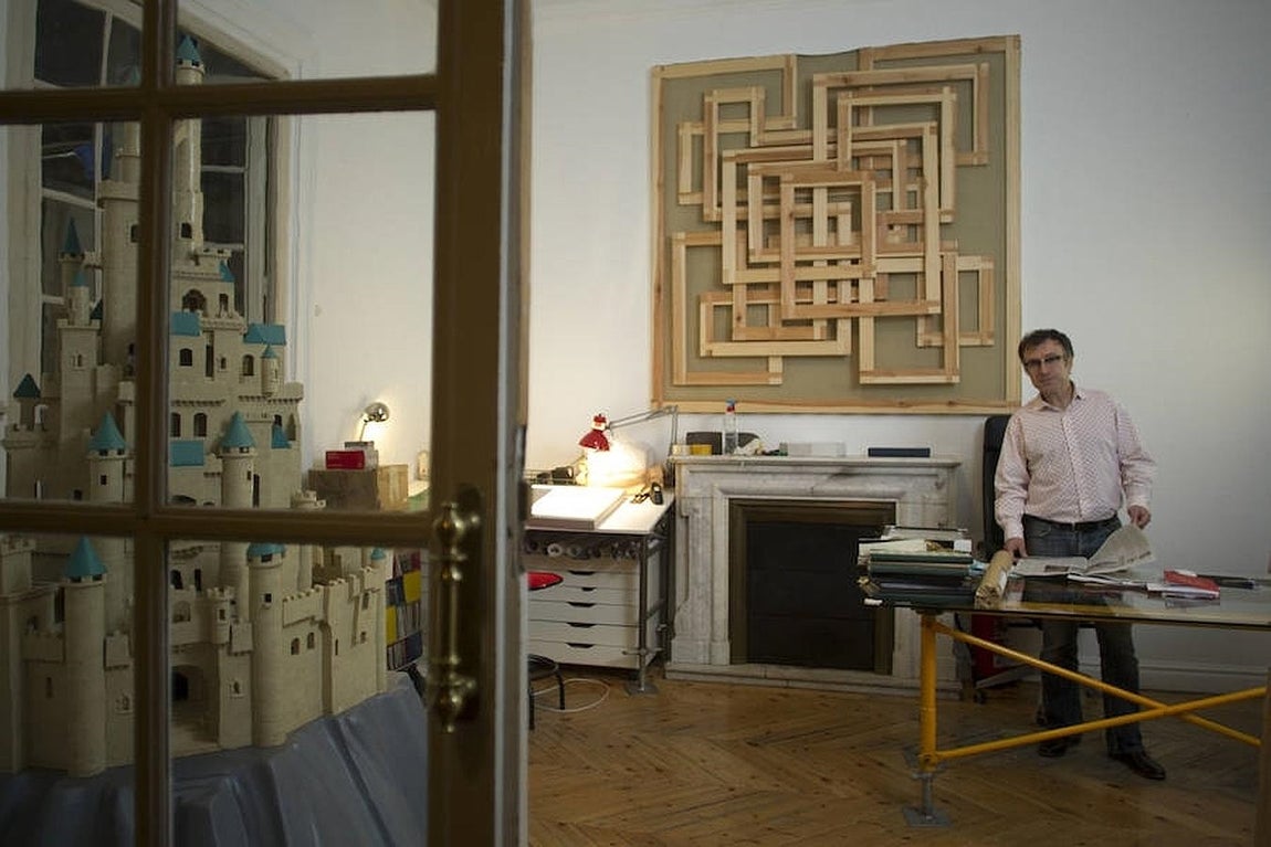 El artista ojea un ejemplar de ABC Cultural, para el que ha hecho el logo del XXV aniversario, en su despacho, rodeado de sus obras. 