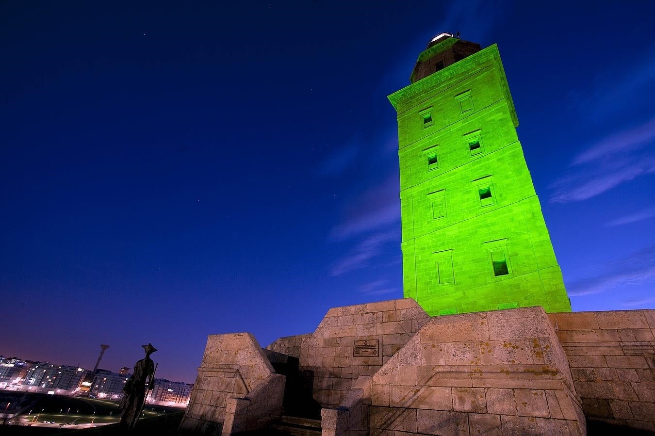 Torre de Hércules, La Coruña. En España se une la #OlaVerde' la ciudad de Marbella, donde se iluminó el arco de entrada a la localidad, el ayuntamiento, el faro y el puerto deportivo. En La Coruña se tiñó de verde la Torre de Hércules. En Tenerife la plaza de España de Adaje. Y en Asturias la torre medieval de Pancar, en Llanes.