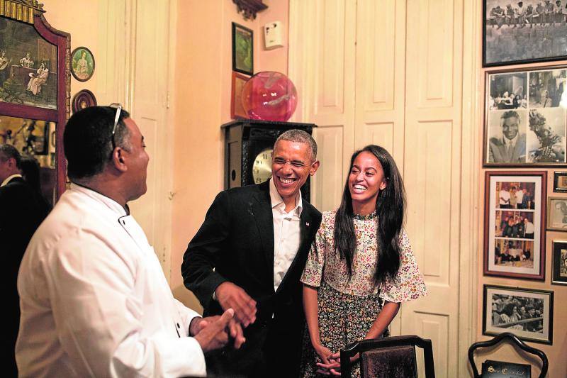 El presidente de EE.UU, Barack Obama, y su hija Malia tratan de hablar en español con el dueño de un restaurante en La Habana, Cuba