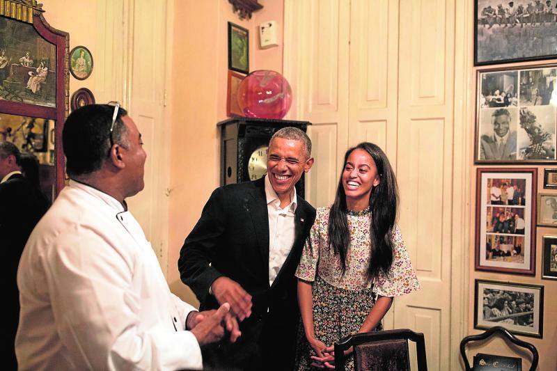 El presidente de EE.UU, Barack Obama, y su hija Malia tratan de hablar en español con el dueño de un restaurante en La Habana, Cuba. 