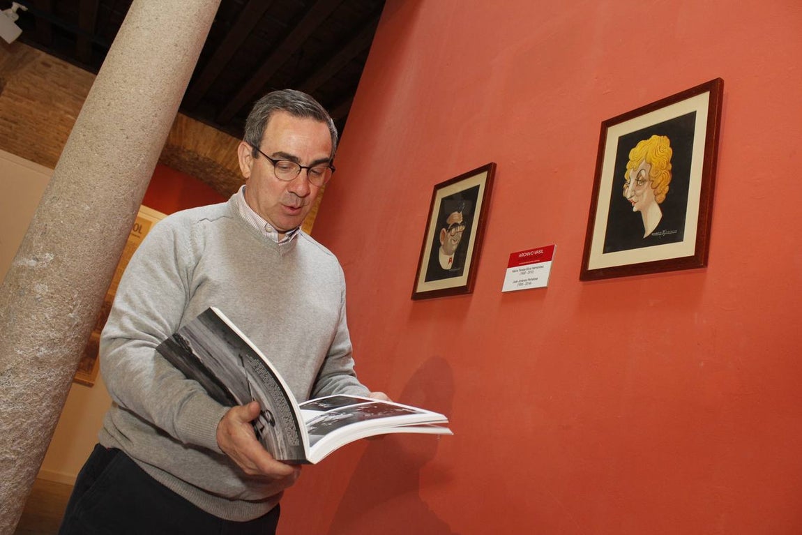 Quique Jiménez Silva, con el libro en sus manos,  junto a un retrato de sus padres. 