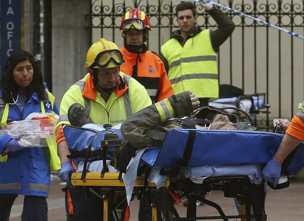 Un bombero en camilla tras ser rescatado por sus compañeros depués del derrumbamiento del edificio. 