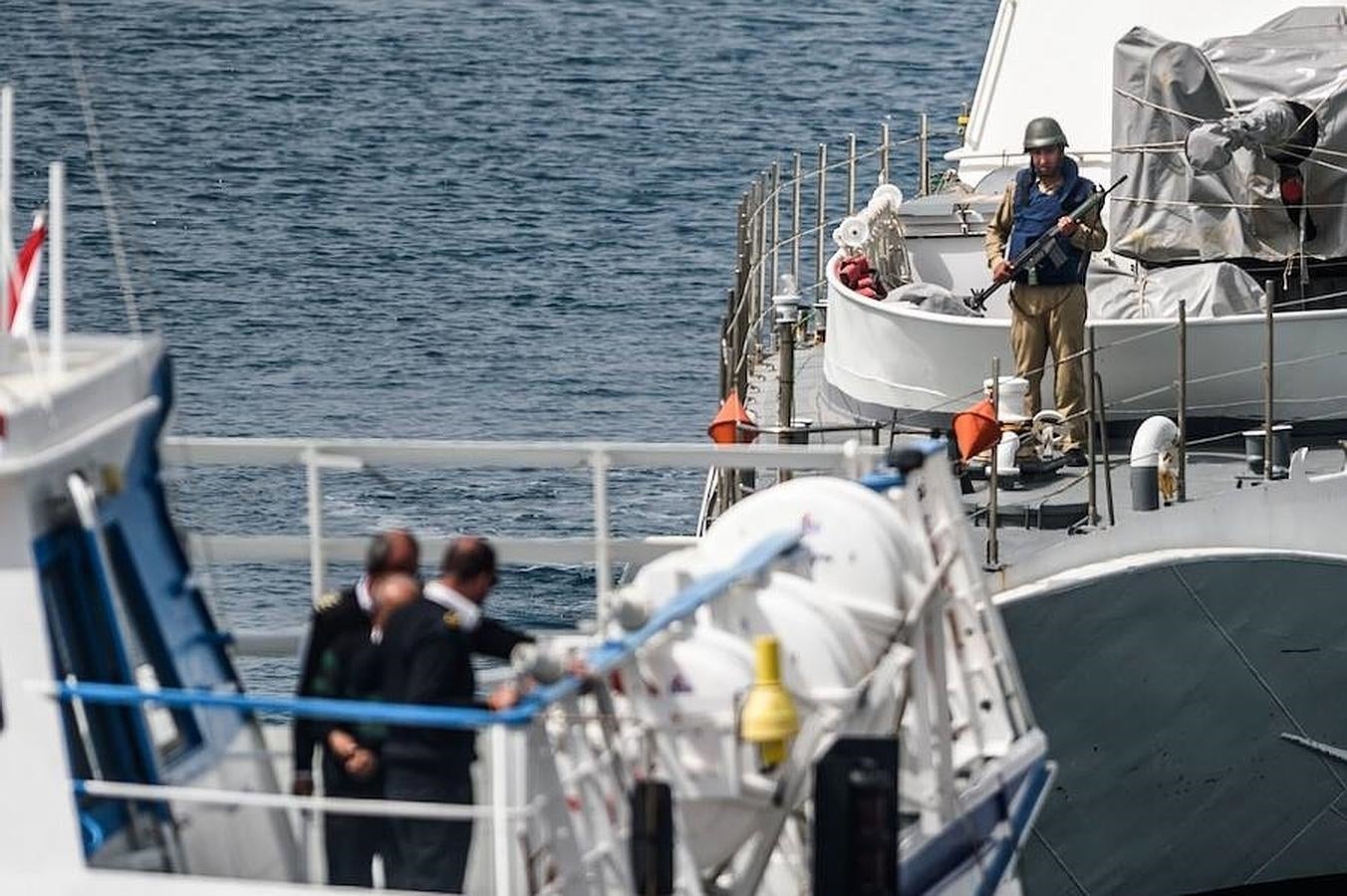 Dos guardacostas observan como llega el ferry con el segundo grupo de deportados desde Lesbos. 