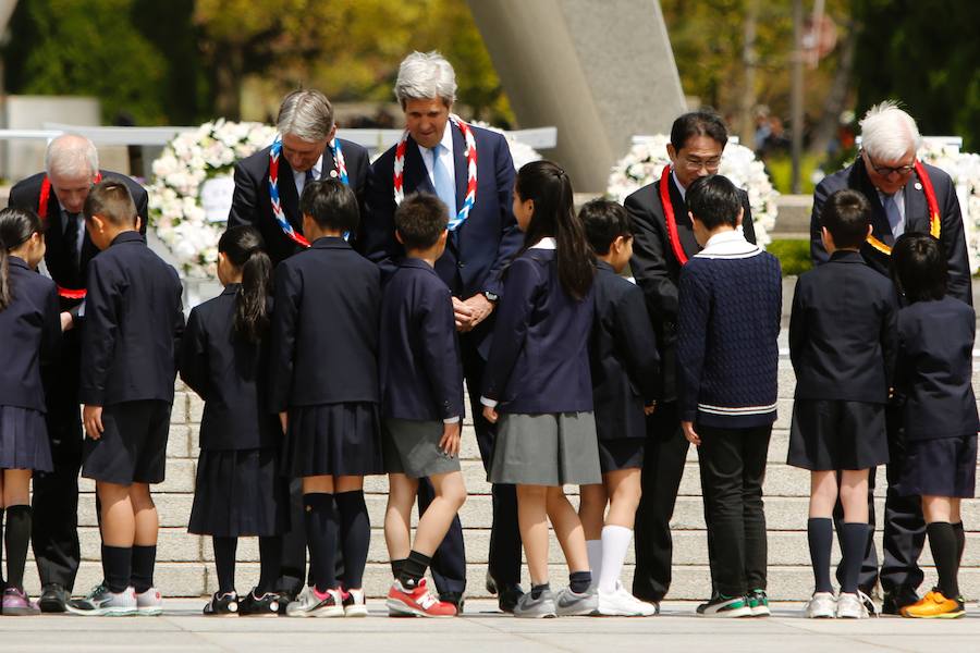 Un grupo de niños entrega coronas hechas con papel a los ministros de Exteriores de (de izquierda a derecha) Canadá, Stephane Dion; Reino Unido,  Philip Hammond; secretario de Estado de EE.UU., John Kerry; Japón, Fumio Kishida, y Alemania, Frank-Walter Steinmeier, este lunes en Hiroshima frente al monumento en memoria de las víctimas de la bomba atómica lanzada en 1945