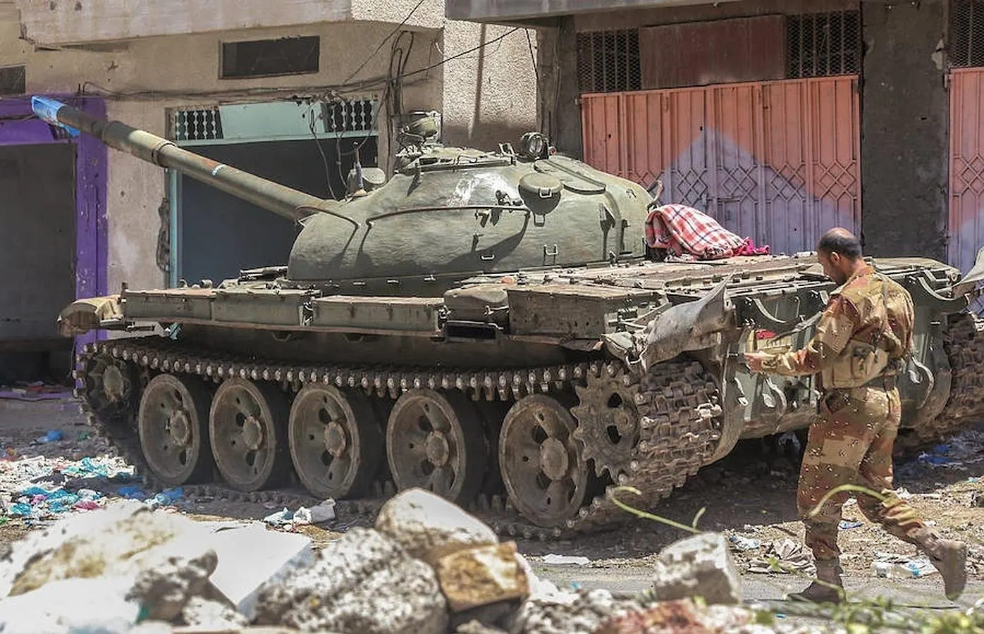Un guerrillero yemení camina al lado de un tanque en la ciudad de Taez 