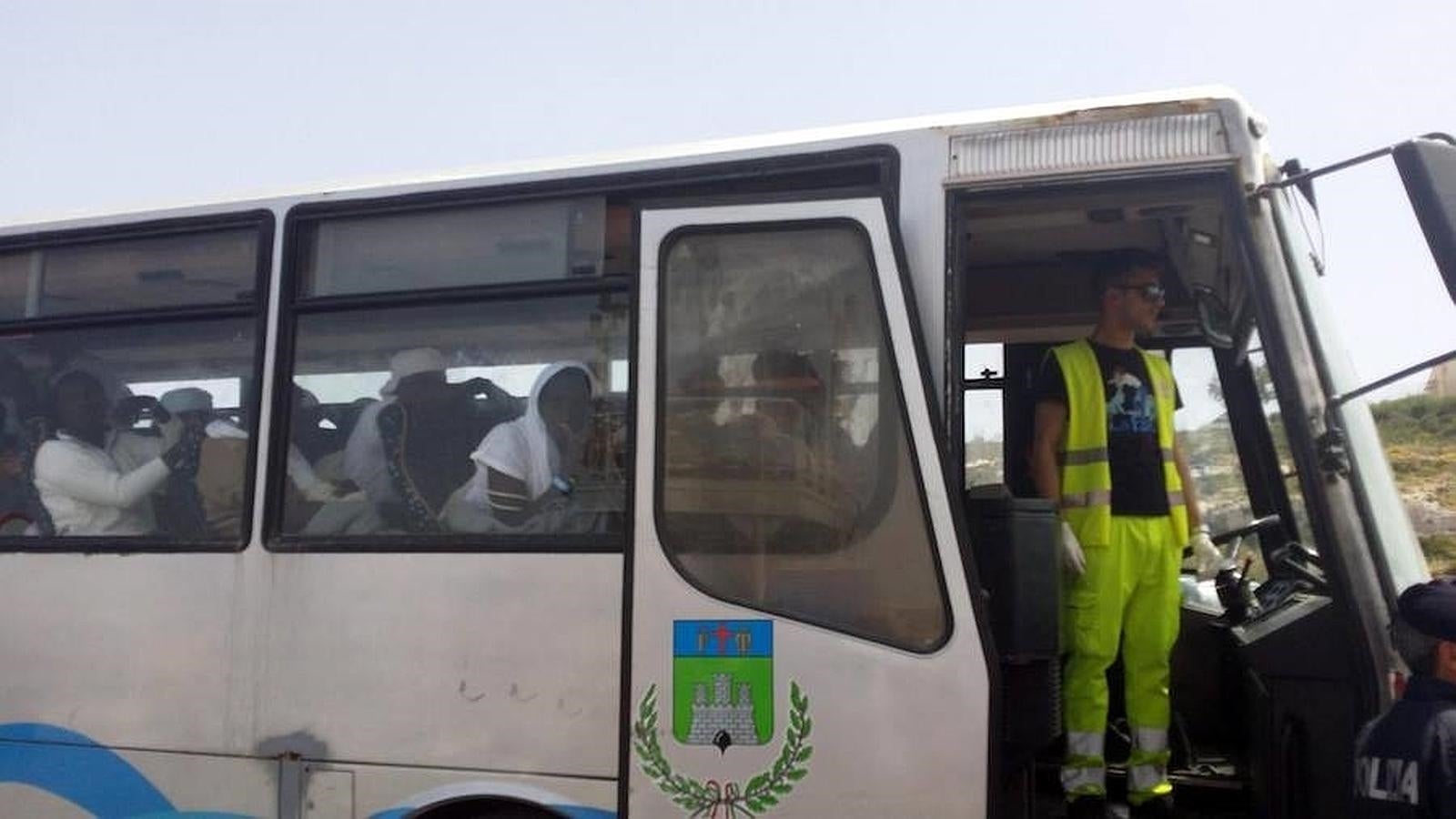 Algunos de los 108 inmigrantes rescatados en alta mar toman un autobús tras desembarcar en Lampedusa. 