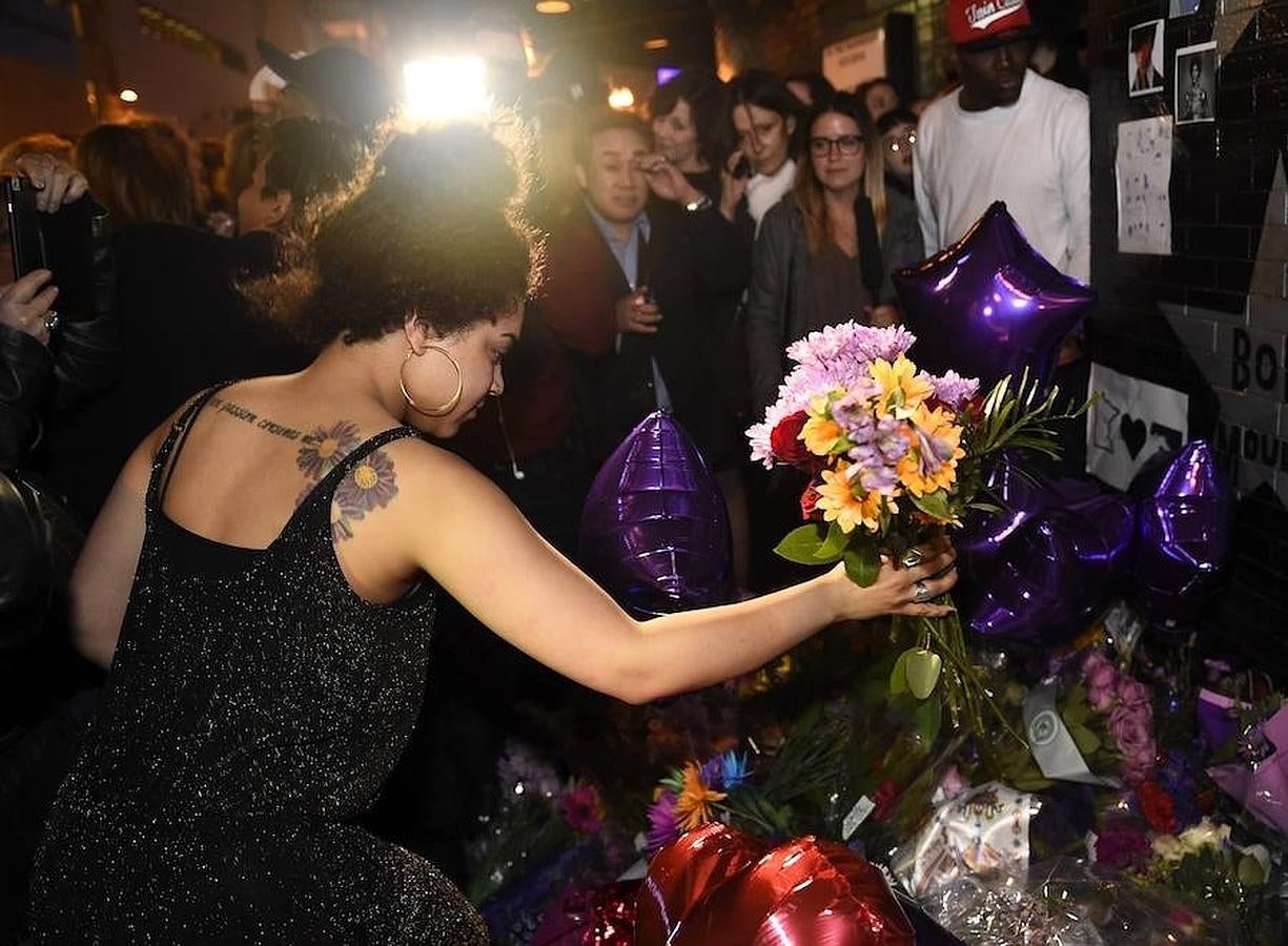 Una admiradora de Prince pone un ramo de flores en su honor