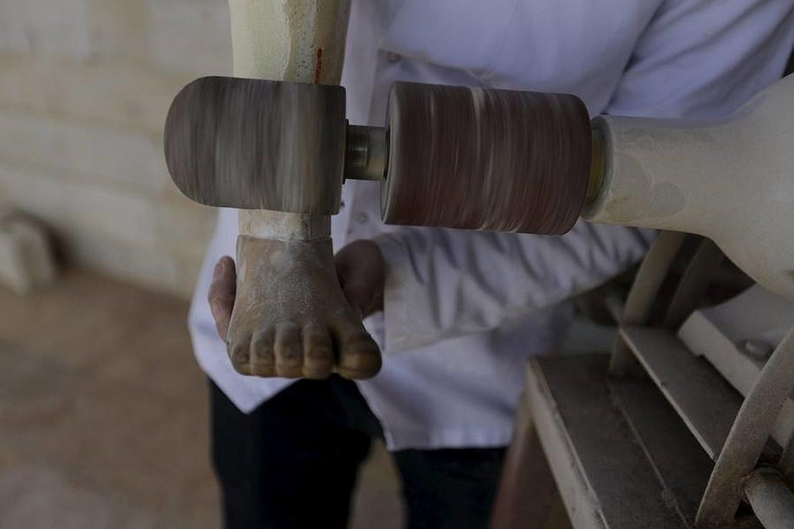 Khamis ultima una pierna artificial en su lugar de trabajo. 