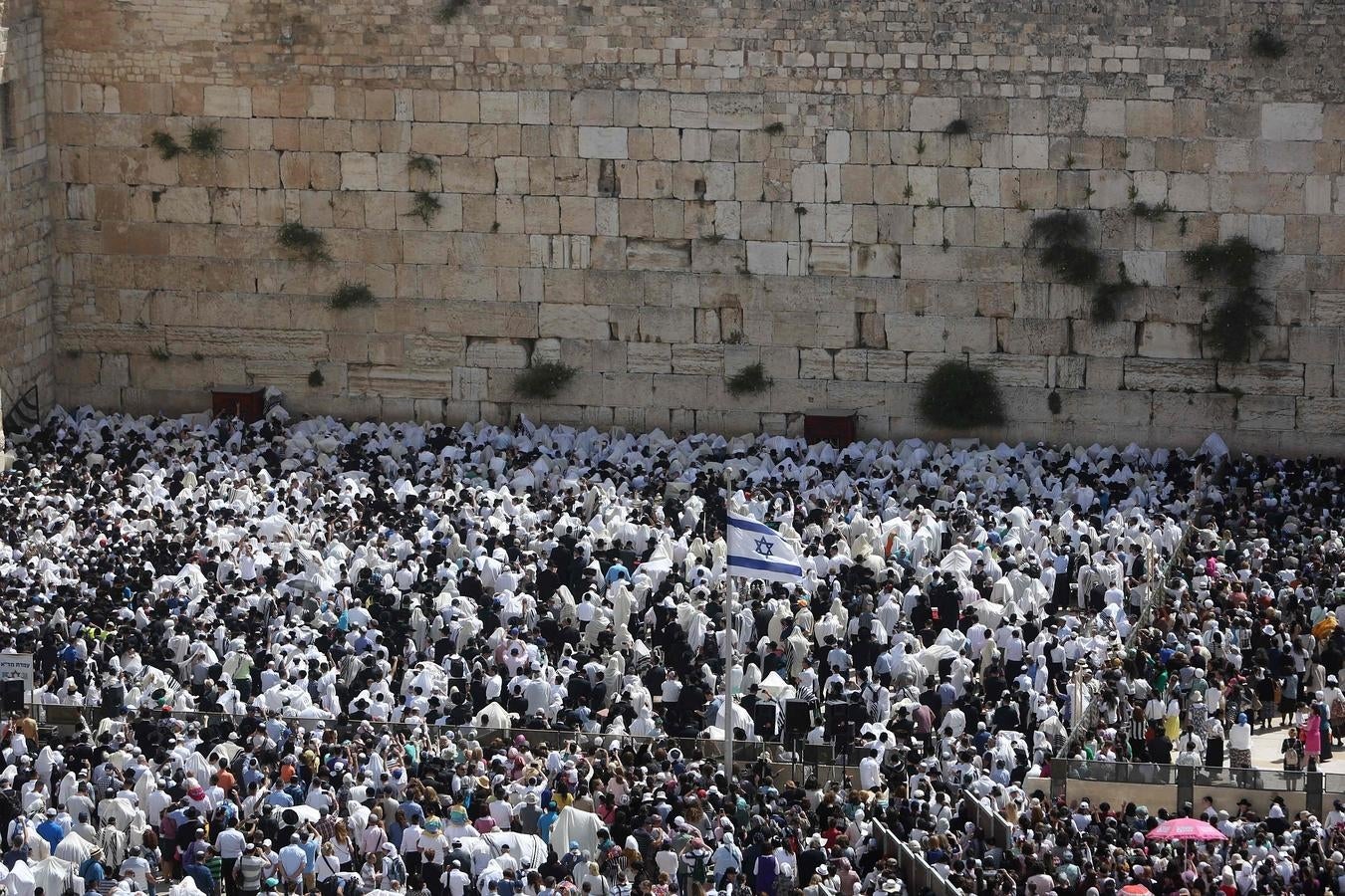 Una bandera de Israel en medio de la multitud que sigue la ceremonia de la Pascua judía. 