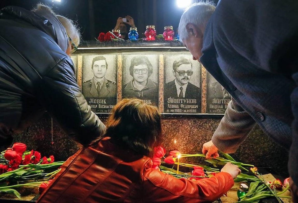 Ucranianos encienden velas en el monumento a los «Héroes de Chernobyl» durante una ceremonia en honor a los «Liquidadores». 
