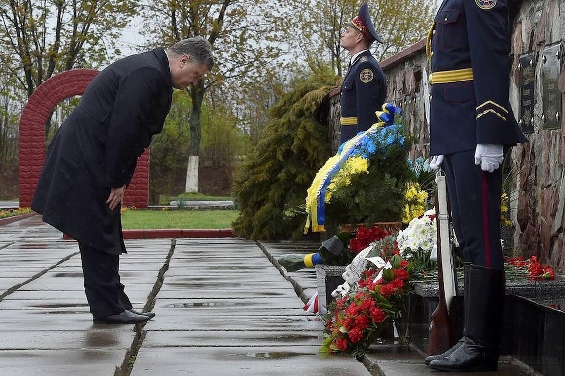 El presidente de Ucrania, Petro Poroshenko. presenta sus respetos en el memorial, levantado cerca de la central nuclear de Chernóbil, después de colocar unas flores. 