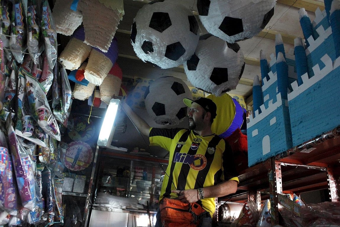 Un hombre utiliza una lámpara en su tienda durante el apagón de luz en San Cristóbal, Venezuela. 