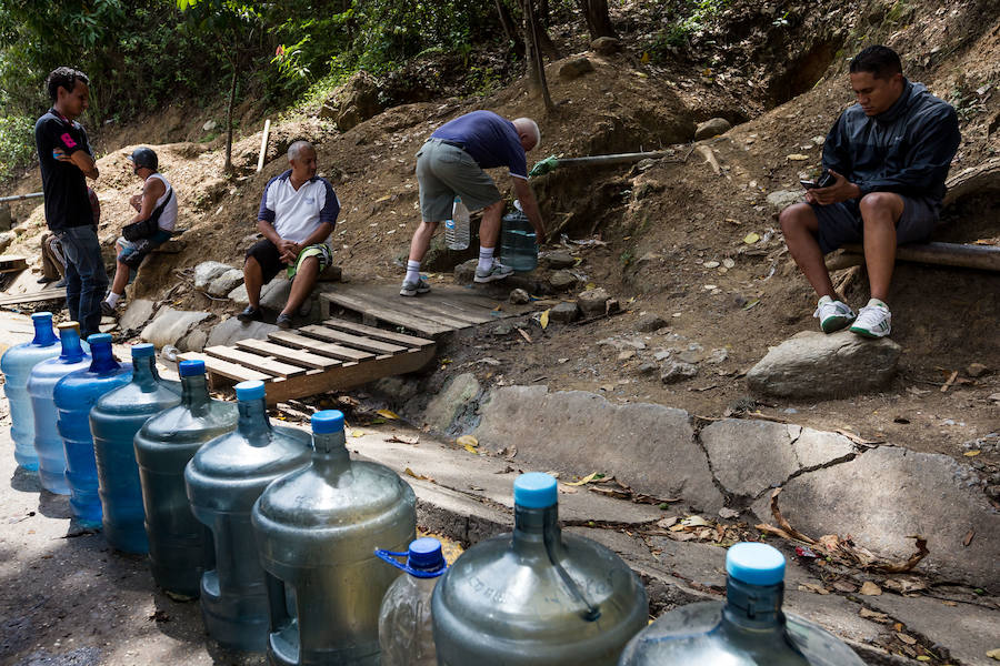 Un grupo de venezolanos espera su turno para recoger agua en el sector La Castellana, en Caracas. 