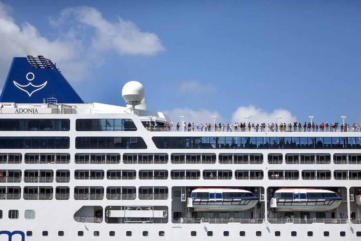 Pasajeros se asoman a la cubierta del crucero. 