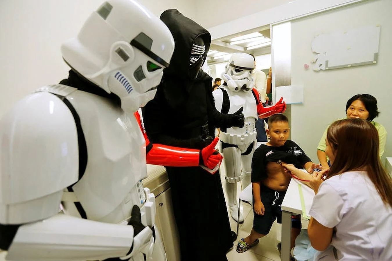 Un grupo de fans, uno de ellos disfrazado de Ben Solo, acompañan a un niño durante su revisión médica