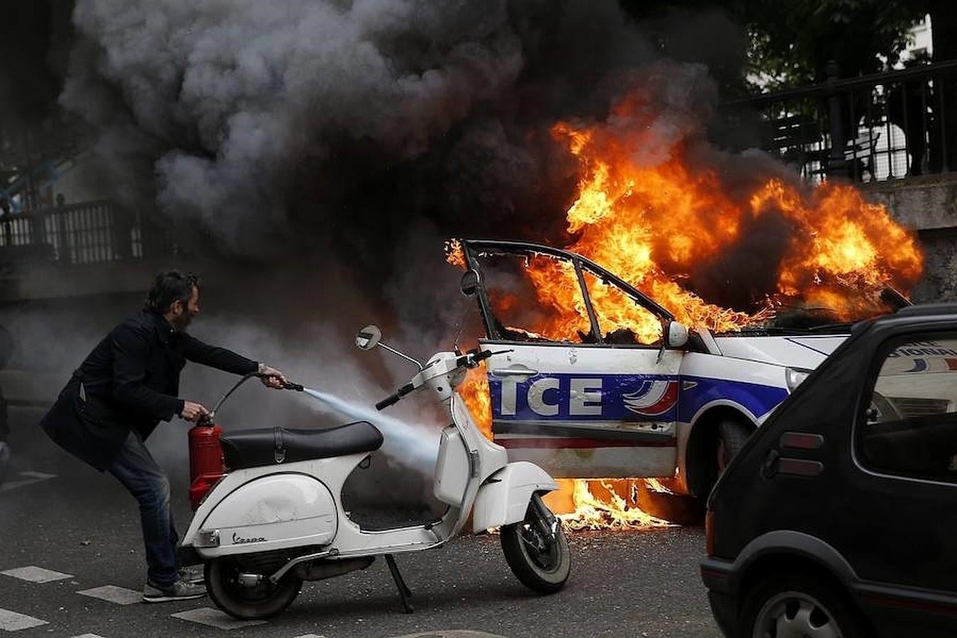 Manifestantes prenden fuego a un coche policial durante una protesta no autorizada contra la violencia policial en las manifestaciones contra la reforma laboral en el país, en París. 