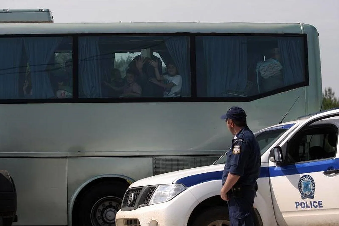Un grupo de refugiados mira desde la ventana de un autobús, mientras abandona la frontera entre Grecia y Macedonia, cerca de la localidad de Idomeni
