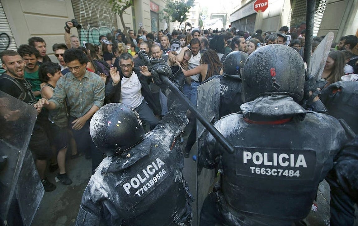 Manifestantes y antidisturbios de los Mossos d'Esquadra, durante los incidentes producidos esta mañana en el barrio de Gràcia de Barcelona. 